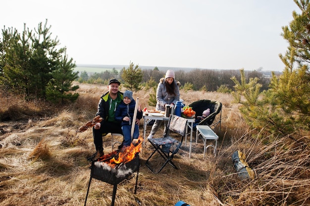 Familie barbecueën op een terras in het dennenbos. Bbq-dag met grill.