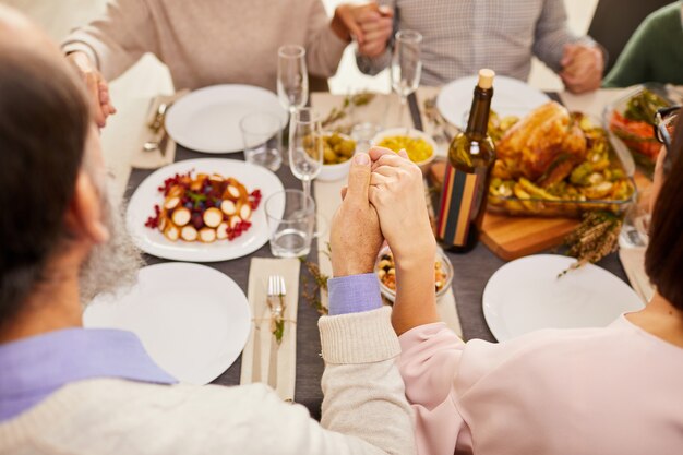 Familie bidden tijdens het diner