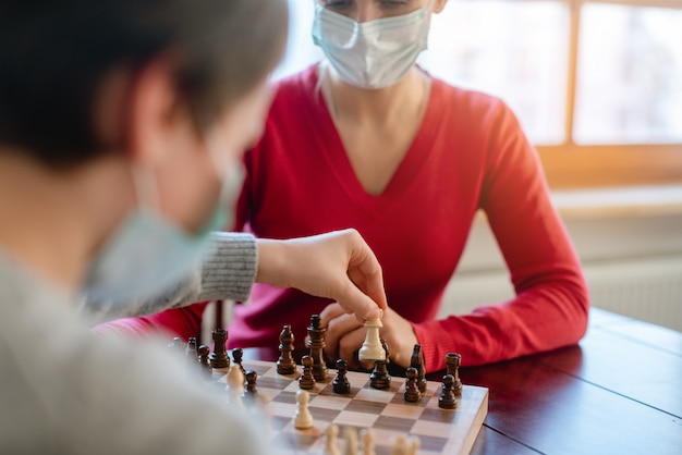 Familie bordspellen spelen tijdens avondklok bewegende schaakstukken