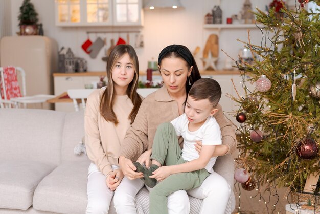 Familie brengt tijd samen door tijdens de kerstvakantie in een versierd huis moeder en haar twee kinderen