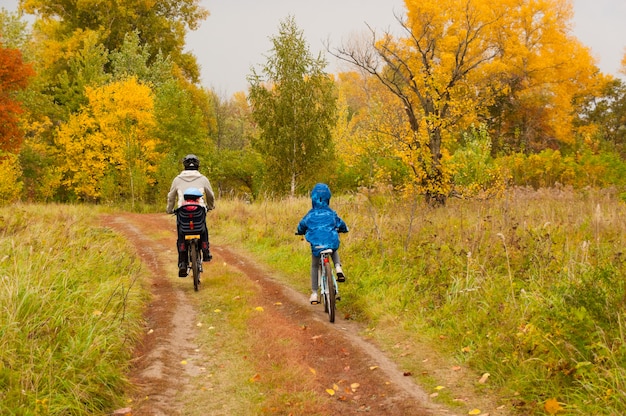 Familie buiten fietsen, gouden herfst in park. Vader en kinderen op fietsen. Familie sport