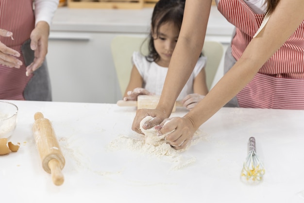 Familie die bakkerij in de keuken maakt