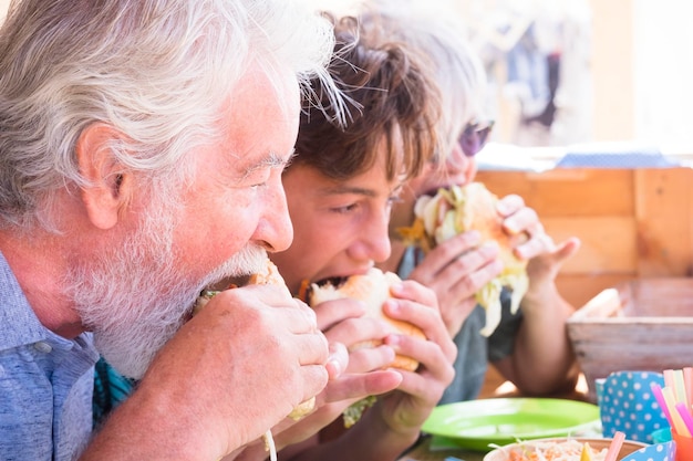 Foto familie die burgers eet in een restaurant.