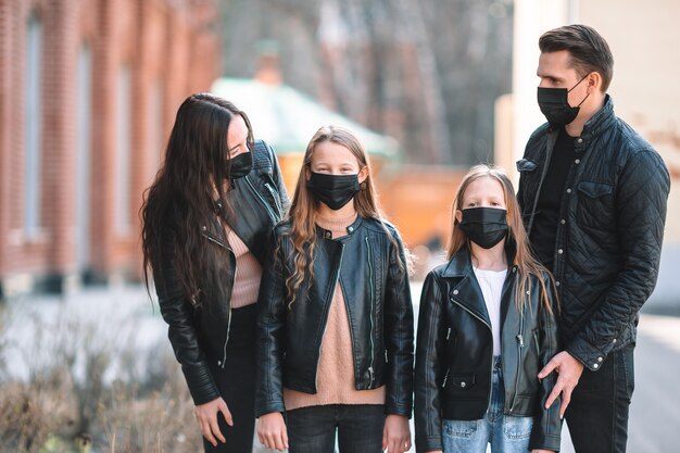 Familie die een masker draagt op een achtergrond van een modern gebouw,