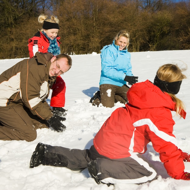 Familie die een sneeuwballengevecht heeft