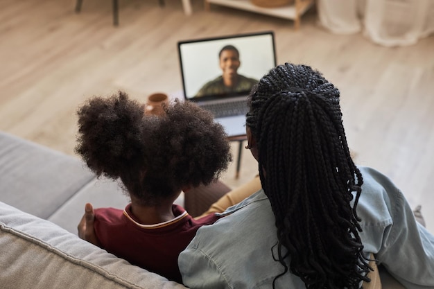 Familie die een videogesprek heeft met hun vader