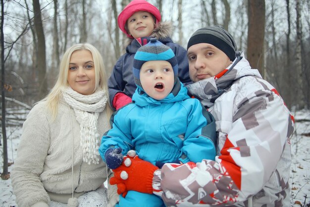 Foto familie die in de winterbos loopt