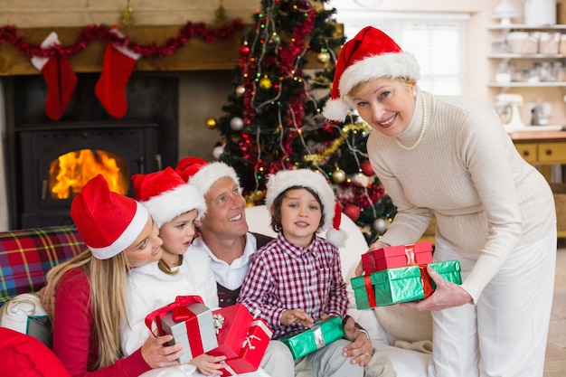 Familie die Kerstmishoed draagt ​​terwijl het houden van cadeaus
