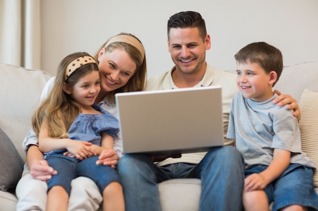 Familie die laptop samen op bank met behulp van