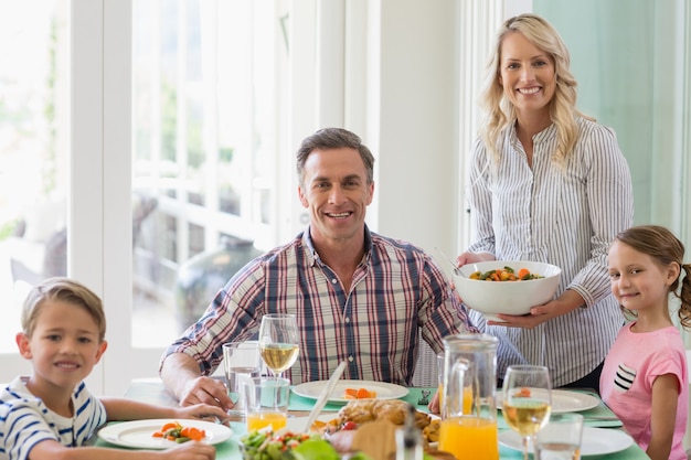 Familie die maaltijd op eettafel hebben thuis