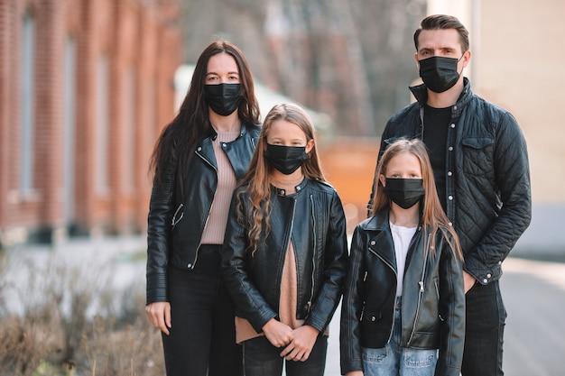 Familie die maskers draagt ter bescherming tegen Coronavirus en grip