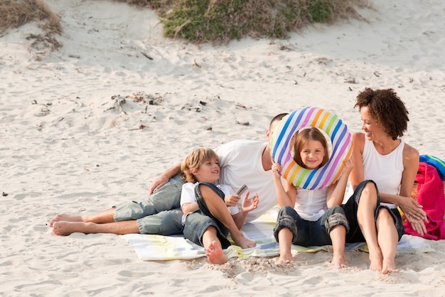 Foto familie die met het zand speelt