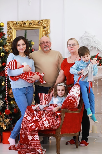 Familie die mooie levende kerstboom verfraait. liefdevolle familie met cadeautjes op de kamer. gelukkige familie op vakantie.