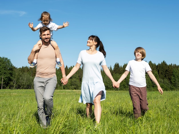 Familie die op de zomerweide loopt