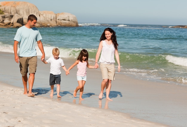 Familie die op het strand loopt