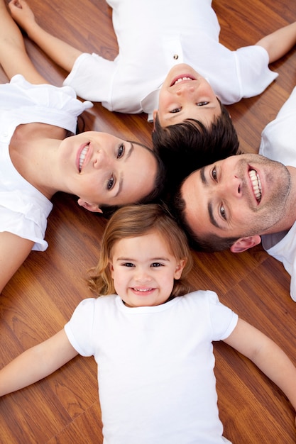 Foto familie die op vloer met hoofden samen ligt