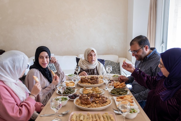 Familie die samen eet met leden van meerdere generaties in een moderne woonkamer