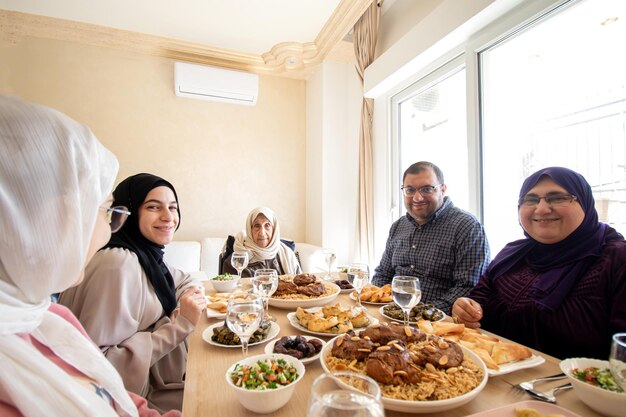 Familie die samen eet met leden van meerdere generaties in een moderne woonkamer