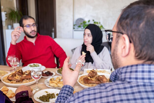 Familie die samen eet met leden van meerdere generaties in een moderne woonkamer