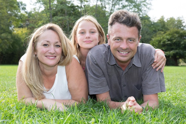 Foto familie die samen op gras in park ligt
