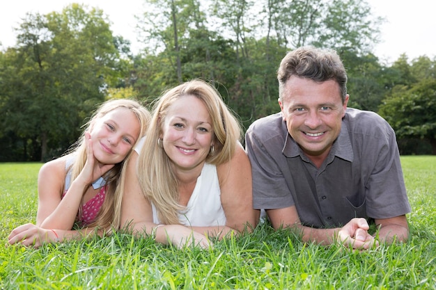 Foto familie die samen op gras in park ligt