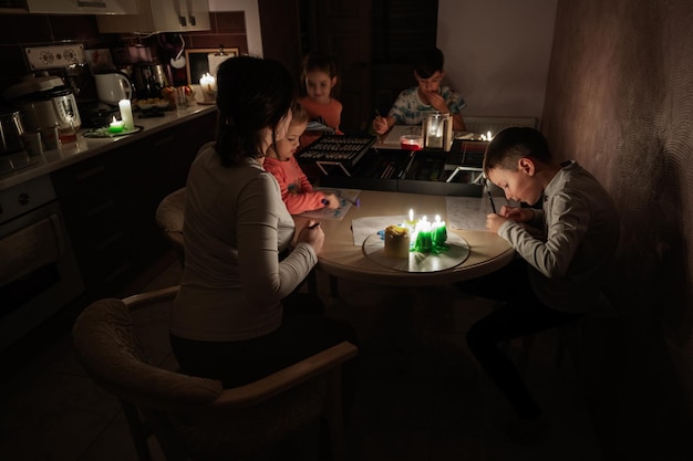 Foto familie die samen tijd doorbrengt tijdens een energiecrisis in europa die black-outs veroorzaakte. kinderen tekenen in black-out
