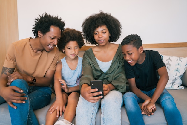 Familie die selfie samen met telefoon thuis nemen.