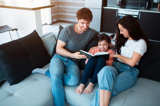 Familie die thuis een boek leest.