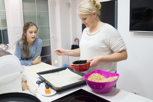 Foto familie die traditionele zoete cake thuis maakt