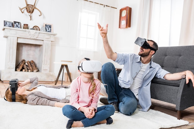 Familie die virtual reality-headsets gebruikt terwijl ze zitten en gebaren