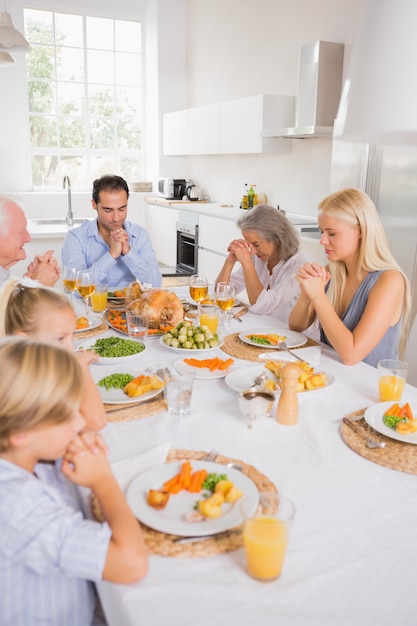 Familie die vóór het eten bidt