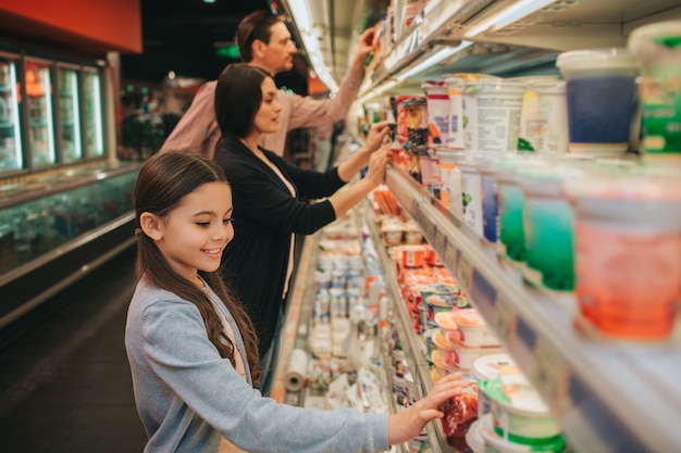 Familie die zich bij zuivelplank bevindt en producten kiest