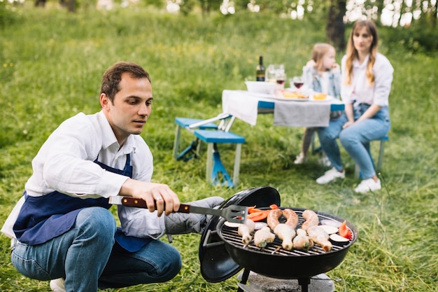 Familie doet een barbecue in de natuur