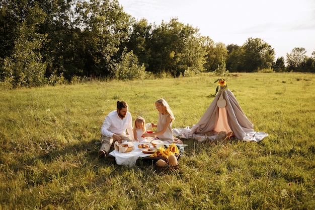 Familie eet op een picknick in de zomer