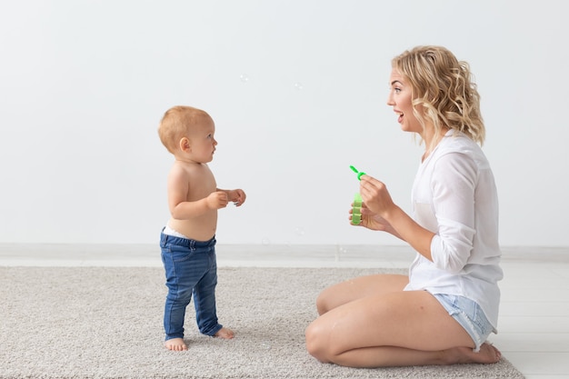 Familie en jeugdconcept - Portret van moeder en baby die thuis spelen en glimlachen.