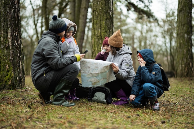 Familie en kinderen met kaart in het bos