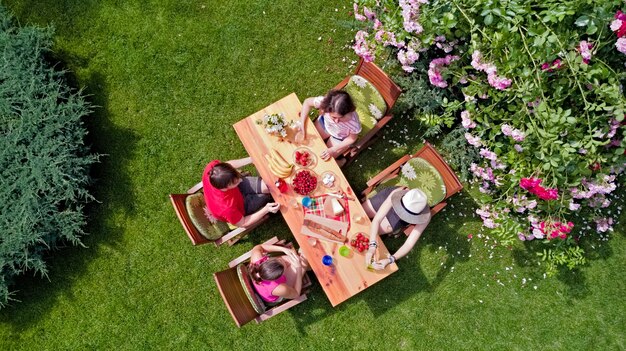 Familie en vrienden die samen buiten eten op zomertuinfeest Luchtfoto van tafel met eten