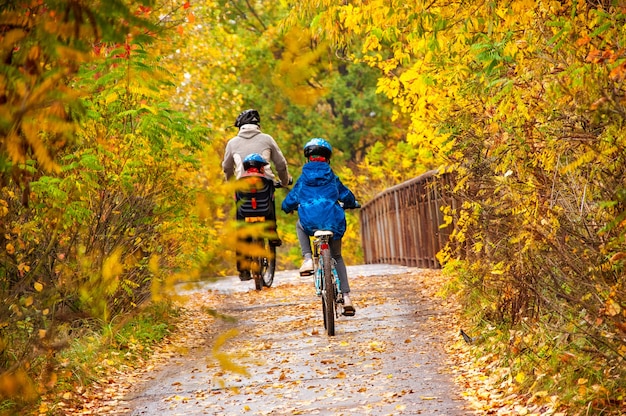 Familie fietsen in gouden herfst park, actieve vader en kinderen fietsen, familiesport en fitness met kinderen buiten