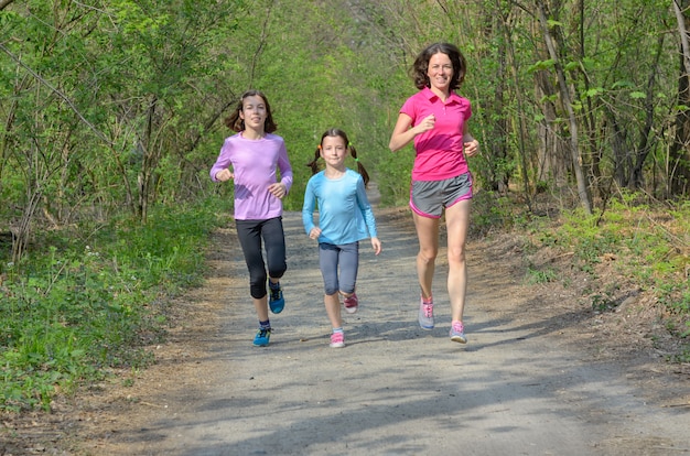 Familie fitness en sport, gelukkige actieve moeder en kinderen joggen buiten, hardlopen in het bos