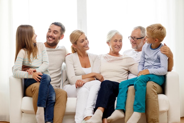 Familie, geluk, generatie en mensenconcept - gelukkige familiezitting op laag thuis