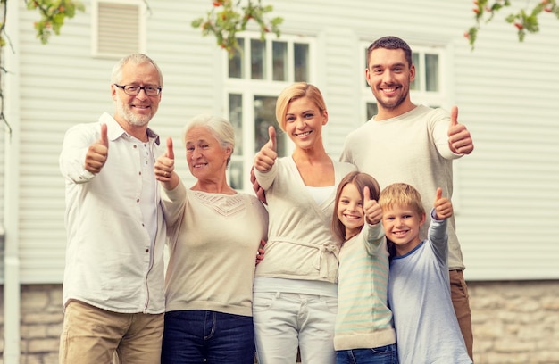 familie, geluk, generatie, huis en mensenconcept - gelukkige familie die buiten voor huis staat