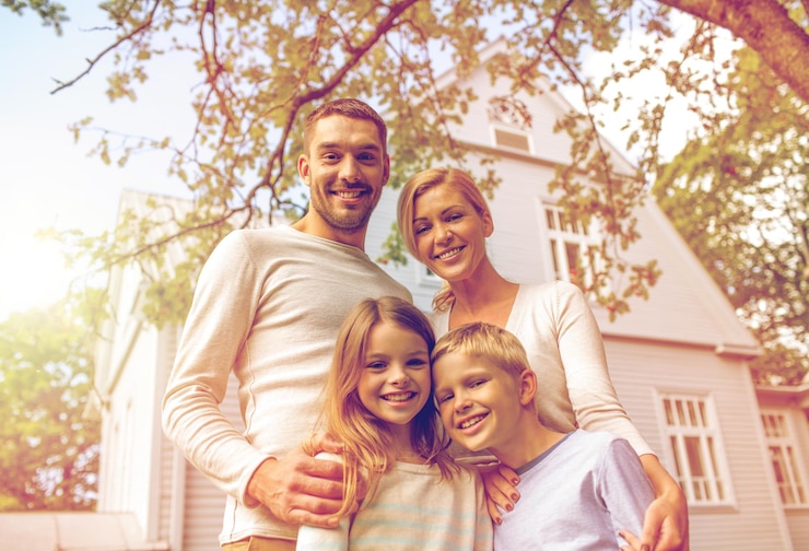 Foto familie, geluk, generatie, huis en mensenconcept - gelukkige familie die buiten voor huis staat