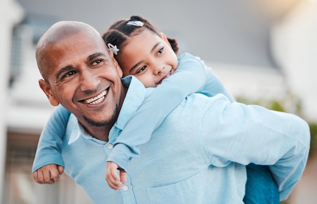 Familie glimlach en vader met meisje op de rug ontspannen in de tuin van het huis om quality time te hechten en buiten te spelen liefde meeliften en gelukkige vader dragen kind op zomervakantie, weekend en vakantie