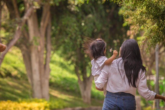 Familie hand in hand terwijl ze overdag door een park lopen in Peru Lima