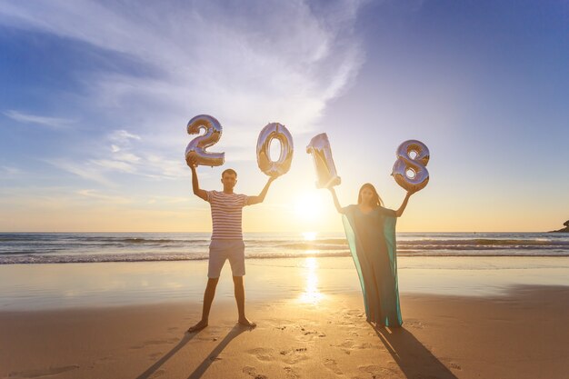 Familie het spelen met de zoon op het strand in de zonsondergangtijd