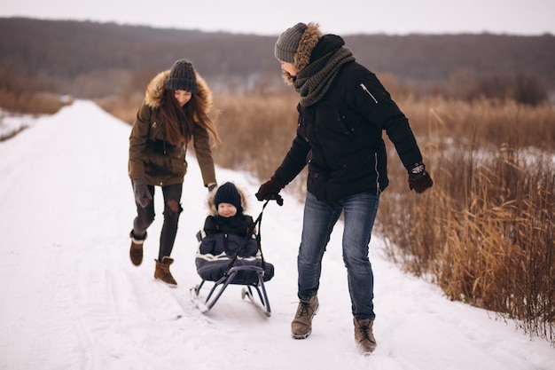 Familie in de winter met zoonssleetocht