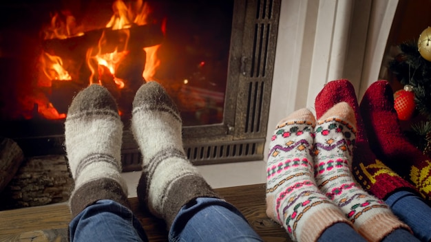 Familie in wollen sokken die Kerstmis viert bij brandende open haard