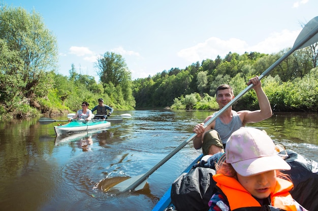 Familie kajaktocht Vader en dochter en bejaarde echtpaar senior en senior een roeiboot op de rivier een waterwandeling een zomeravontuur Milieuvriendelijk en extreem toerisme actieve en gezonde levensstijl