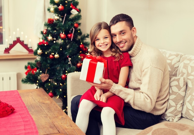 Familie, kerst, kerst, winter, geluk en mensen concept - lachende vader en dochter met geschenkdoos