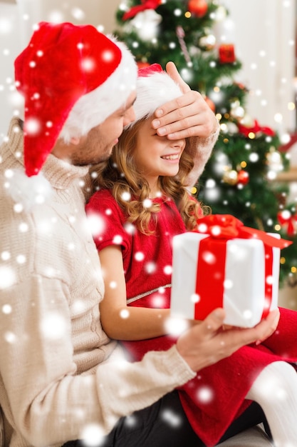 familie, kerst, kerst, winter, geluk en mensen concept - lachende vader verrassing dochter met geschenkdoos die ogen bedekt met hand